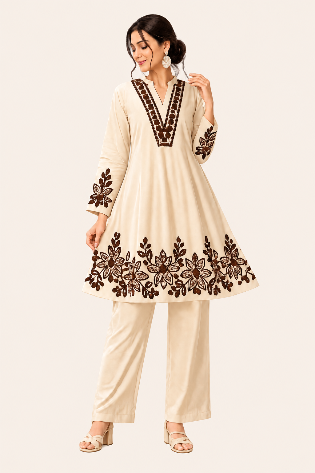 Full-length woman in a cream kurta with brown floral embroidery on a light cream background